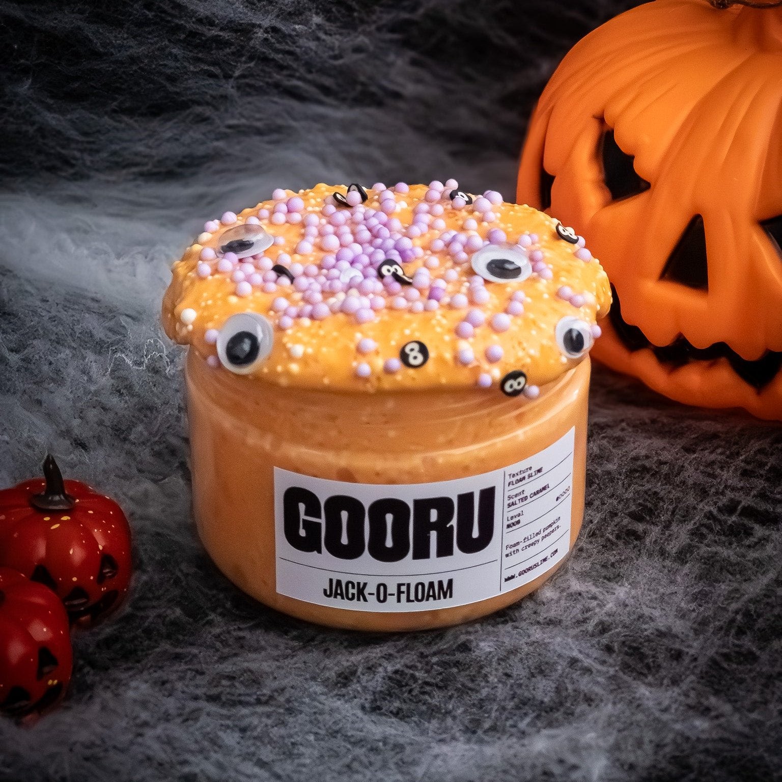 Bright orange foam-filled slime with soft, squishy texture, featuring googly eyes and spooky Halloween theme. Perfect for sensory play and stress relief, with vibrant color and non-sticky finish.