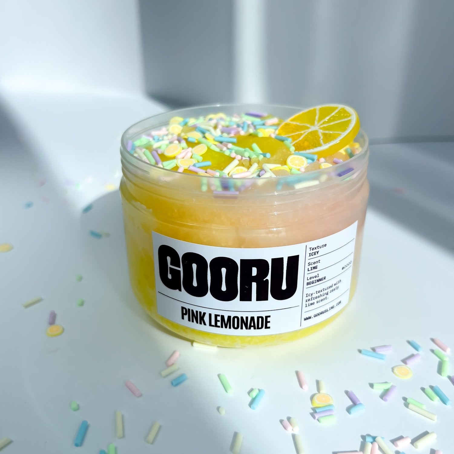 A product shot of Pink Lemonade slime, with lemon charm and colorful sprinkles, designed and manufactured  by Gooru Slime, Dubai, UAE