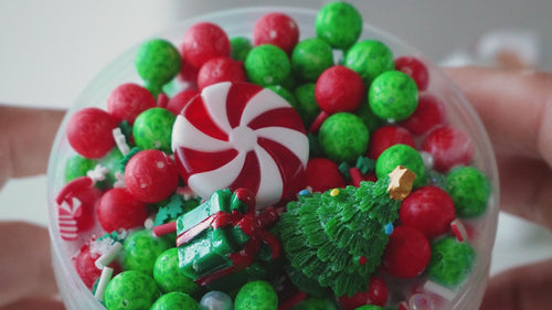 A video showcasing Gooru’s Winter Drop, featuring festive slime jars with vibrant textures, holiday-themed charms, and a snowy, cheerful backdrop.